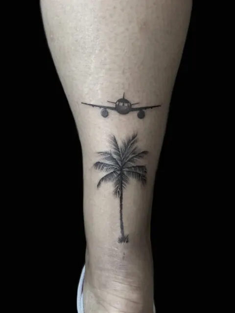 Tatouage minimaliste avec avion et palmier