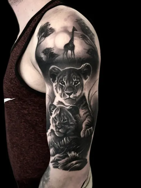 Lionne et ses petits dans la savane avec girafe, Black & Grey sur le haut du bras