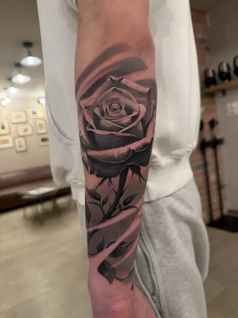 Realistische Rose mit Blättern und Ranken am Unterarm, Black & Grey